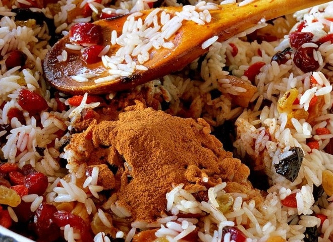 1. Этап. Тыква запеченная с сухофруктами: Отвариваем рис до полуготовности. Смешиваем его с промытыми сухофруктами и ягодами. Приправляем корицей и медом, перемешиваем начинку.