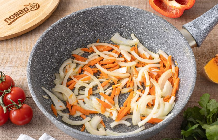 1. Этап. Овощное рагу по-домашнему: Разогрейте сковороду на среднем огне и обжарьте репчатый лук с морковью 2-3 минуты до мягкости и легкого золотистого цвета.