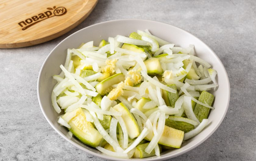 1. Этап. Кабачок маринованный в соевом соусе на зиму: Добавьте тонко нарезанный полукольцами репчатый лук и измельчённый чеснок.