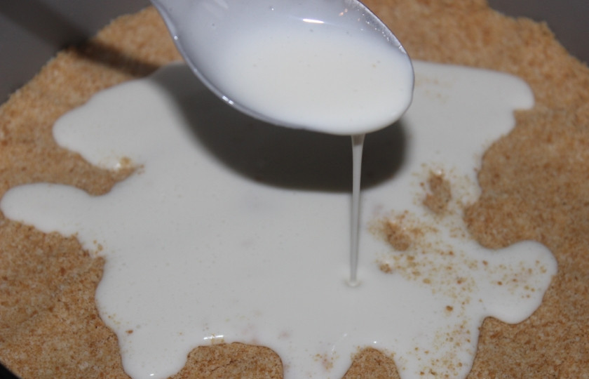 1. Этап. Творожный торт с бананом: В форму для выпечки утрамбуйте слой печенья равномерно, а сверху вылейте творожную массу.