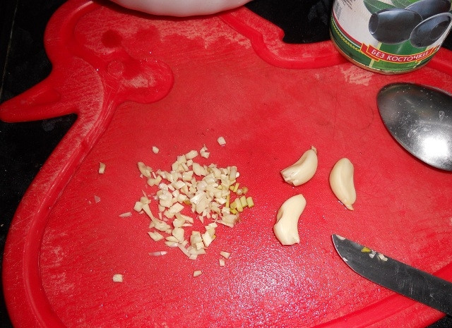 1. Этап. Салат из кальмаров и оливок: Мелко нарежьте чеснок.