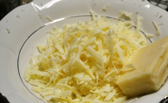 1. Этап. Куриная грудка с картофелем: 6. Твердый сыр натрите на крупной терке в миску, измельчите запеченный чеснок и добавьте его к сыру.