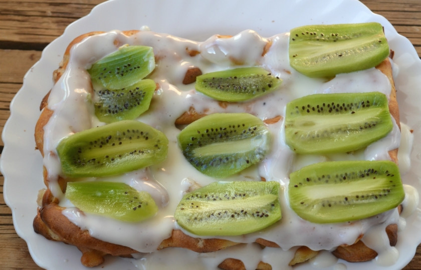 1. Этап. Торт из заварного теста с фруктами: Накройте вторым коржом из заварного теста, снова смажьте его кремом, а сверху выложите тонкие пластины киви.