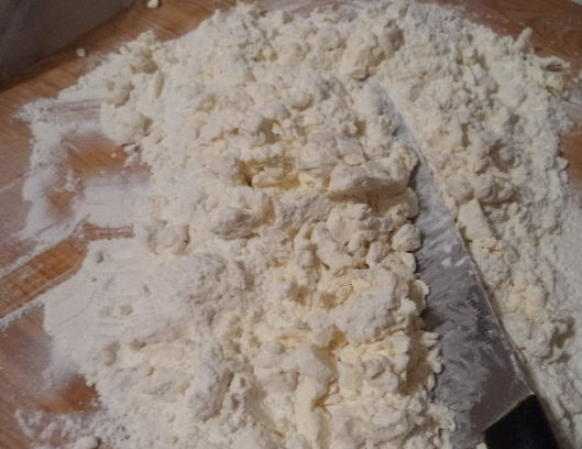 1. Этап. Быстрый рецепт слоеного теста: Муку просеиваем, холодный маргарин рубим ножом и перетираем с мукой до состояния крошки.