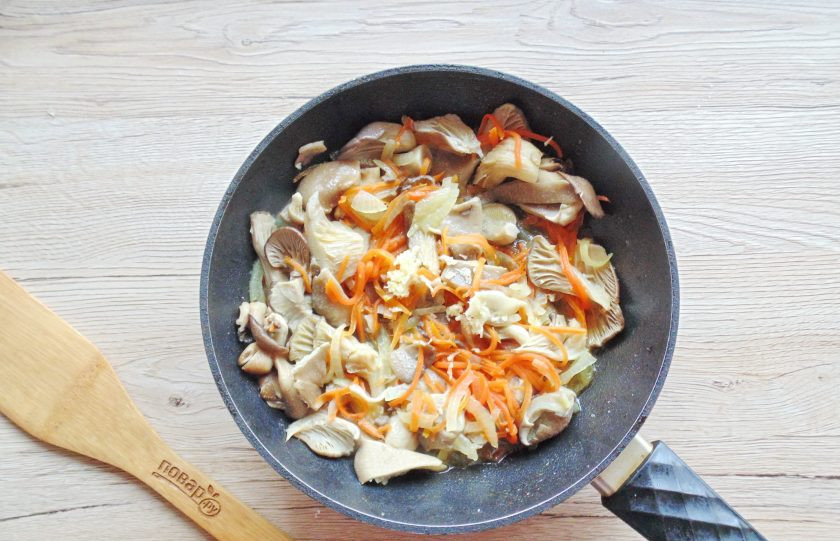 1. Этап. Фунчоза с древесными грибами: Посолите, поперчите и добавьте измельчённый чеснок.