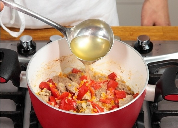 1. Этап. Телятина тушеная с овощами: Добавляем бульон. Спустя 15 минут добавляем в кастрюлю нарезанные грибы и зеленый горошек. Готовим еще 15-20 минут, пока мясо не станет мягким.