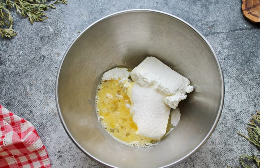 1. Этап. Булочки из слоеного теста с творогом и яблоком: Включите духовку разогреваться до температуры 180 градусов. В миску выложите творог, всыпьте сахар, щепотку соли и влейте половину перемешанного яйца. Добавьте ванильный сахар и хорошо перемешайте.