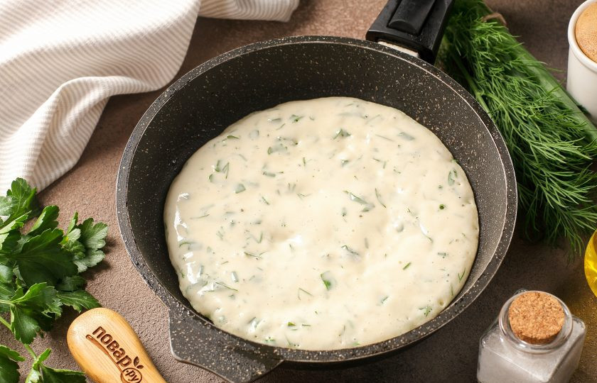 1. Этап. Лепёшки с зеленью на кефире на сковороде: Разогрейте сковороду и смажьте маслом. Тесто выкладывайте ложкой, придавая круглую форму, распределяя по всей сковороде.