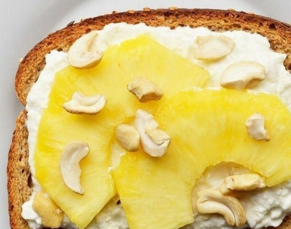 1. Этап. Быстрые и полезные завтраки: На следующий ломтик разложите творог. Сверху разрезанный пополам ананас и орешки кешью.