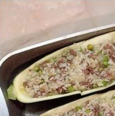 1. Этап. Кабачки, фаршированные рисом и тушенкой: Выложить лодочки из кабачков в форму или противень и наполнить начинкой.