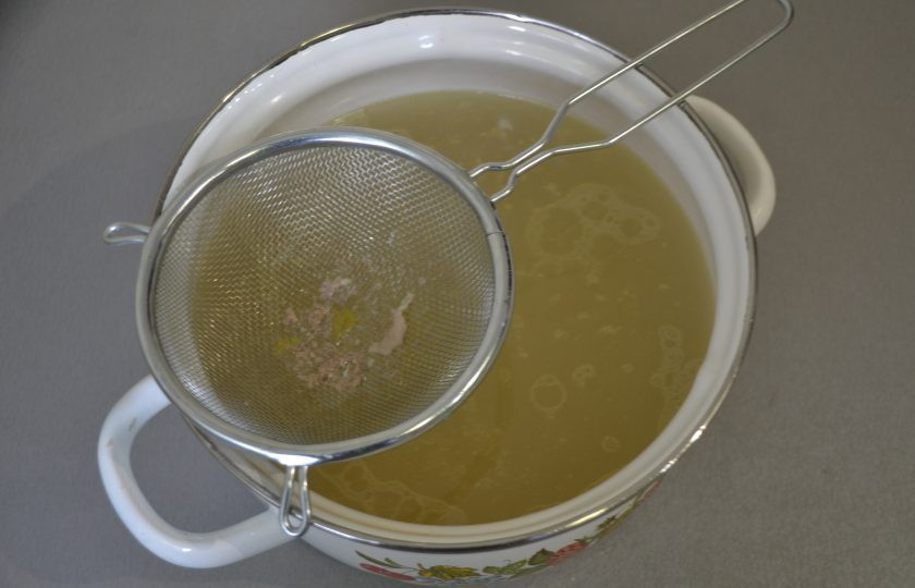 1. Этап. Куриный суп с сырными шариками: Готовый куриный бульон процедите через сито и снова поставьте на огонь.