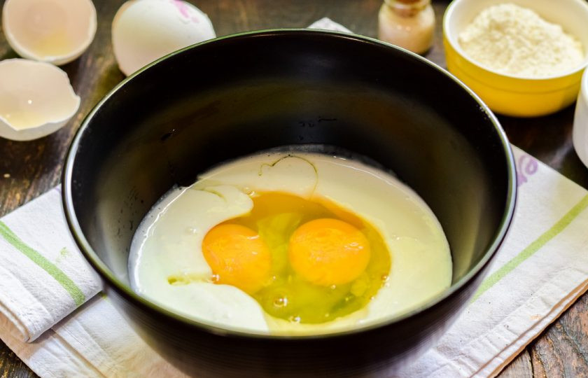 1. Этап. Оладьи на кефире без масла: Добавьте в кефир щепотку соли и куриные яйца.