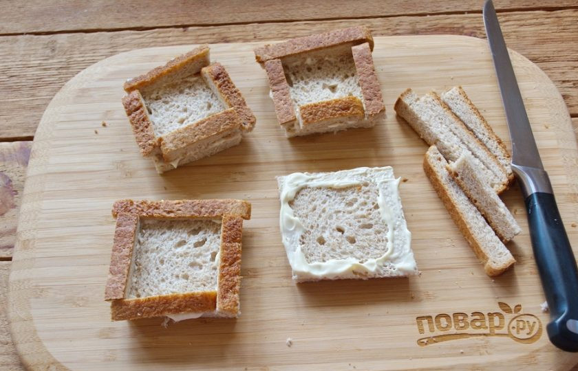 1. Этап. Тосты Карбонара: Края каждого кусочка смажьте майонезом. Обрезанными кусочками корочки декорируйте хлеб, выложив бортики по периметру.