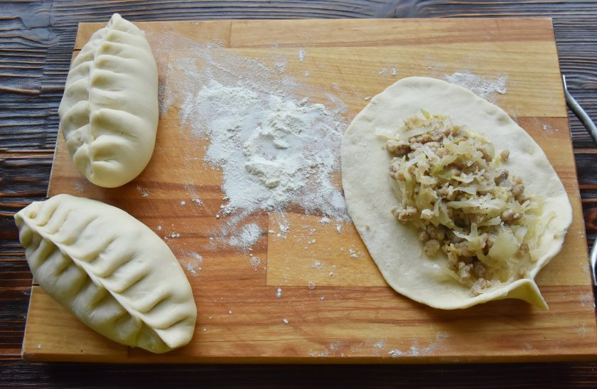 1. Этап. Пигоди по-корейски: Каждую заготовку из теста разложите в овальную лепешку. Края лепешки сделайте потоньше, чем середина. Выложите по центру начинку.