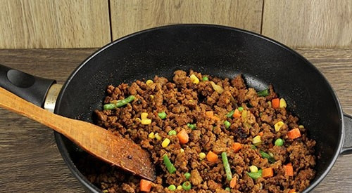 1. Этап. Запеканка с фаршем: В почти готовый фарш добавьте овощную смесь. Всё перемешайте.