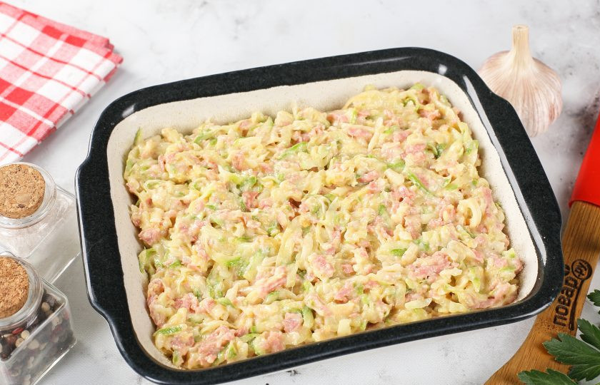 1. Этап. Запеканка из кабачков с копчёной колбасой и сыром: Жаропрочную форму смажьте маслом. Дно и бока присыпьте мукой или манкой. Выложите готовую массу и выпекайте в разогретой до 200 градусов духовке около 30 минут.