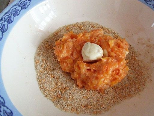 1. Этап. Морковные котлеты на скорую руку: 4. В тарелку насыпать панировочные сухарики. Параллельно поставить на огонь сковороду с растительным маслом разогреваться. Небольшую часть морковного фарша выложить в сухари. Можно сделать морковные котлеты на скорую руку в домашних условиях с небольшим сюрпризом. Это может быть чайная ложка плавленого сыра, зелень или орешек, например.