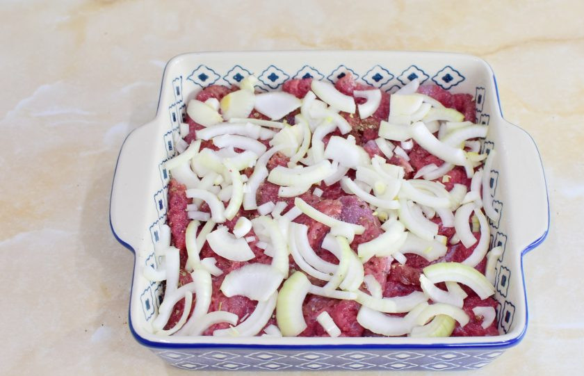 1. Этап. Телятина по-Орловски: Следом разложите кусочки мяса и нарезанный лук.