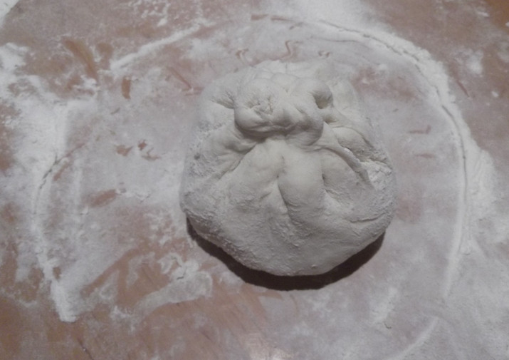 1. Этап. Хычин с домашним сыром: Тесто разделяем на кусочки и раскатываем в небольшие лепешки. Внутрь каждой лепешки кладем начинку. Края теста поднимаем и защипываем сверху.