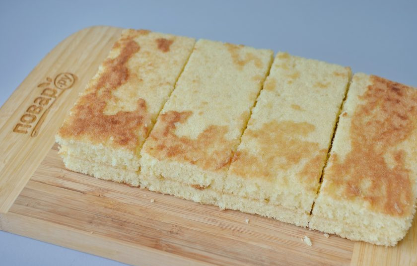 1. Этап. Кокосовые пирожные со сгущенкой: 8. Разрежьте остывший бисквит на 2 части, положите одну часть на вторую, срежьте края, подровняйте. Если размер формы будет больше, то пирожные получатся более тонкими, тогда и количество их увеличится.