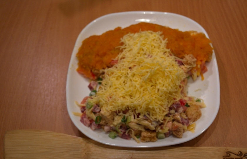 1. Этап. Салат Обезьянка с сухариками: Ушки и часть головы задекорируйте отварной морковкой, натертой на терке. Саму мордочку закройте сыром.