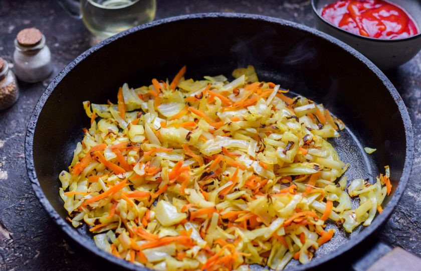 1. Этап. Капуста с аджикой: Сковороду прогрейте и добавьте масло, выложите капусту и морковь, жарьте 5-7 минут, до румяности.
