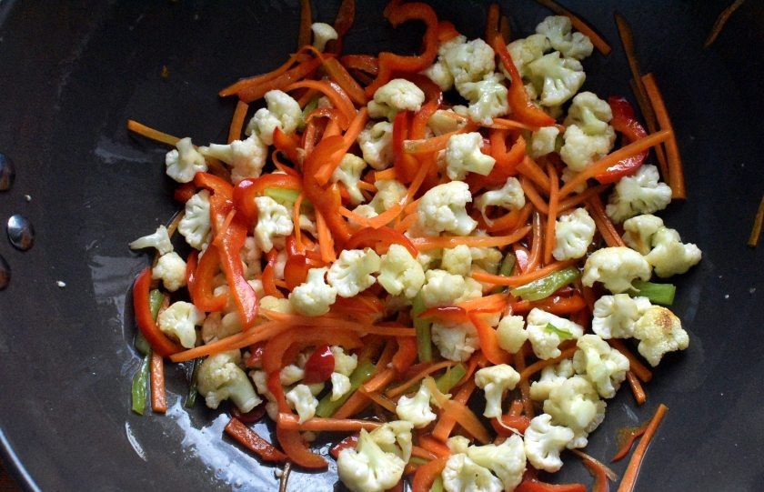 1. Этап. Цветная капуста с яйцами: Разогрейте в воке масло и обжарьте капусту пару минут, постоянно помешивая. Затем добавьте морковь и перец. Жарьте еще пару минут, так же помешивая.