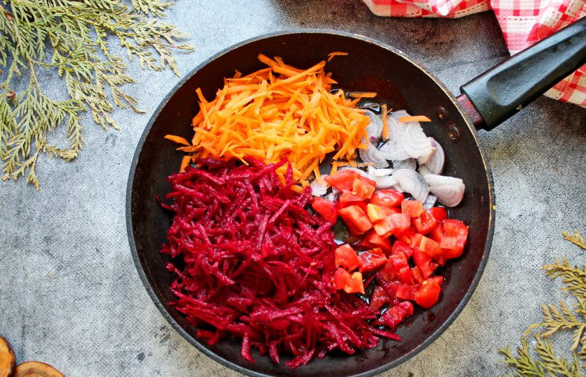 1. Этап. Борщ без капусты: Пока варится мясо, приготовьте зажарку. В сковороду налейте растительное масло и разогрейте на среднем огне. Морковь и свеклу натрите на средней терке. Репчатый лук порежьте, помидоры нарежьте средним кубиком. Выложите овощи в сковороду.