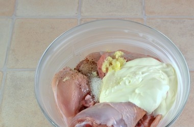 1. Этап. Картофель с курицей в духовке: Кусочки курицы обваляйте в сметане, измельчённом чесноке, соли и перце.