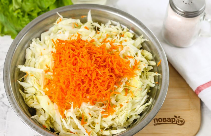 1. Этап. Молодая квашеная капуста: Морковь очистите от кожуры, промойте в воде и натрите на терке с мелкими ячейками. Добавьте натертую массу в емкость.