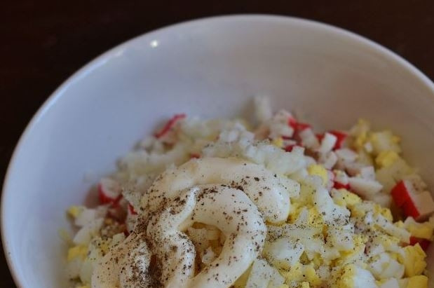 1. Этап. Салат с крабовыми палочками, яйцом и майонезом: Заправьте салат майонезом, посолите и поперчите по вкусу. Тщательно все перемешайте и поставьте в холодильник на пару часов, чтобы салат настоялся.