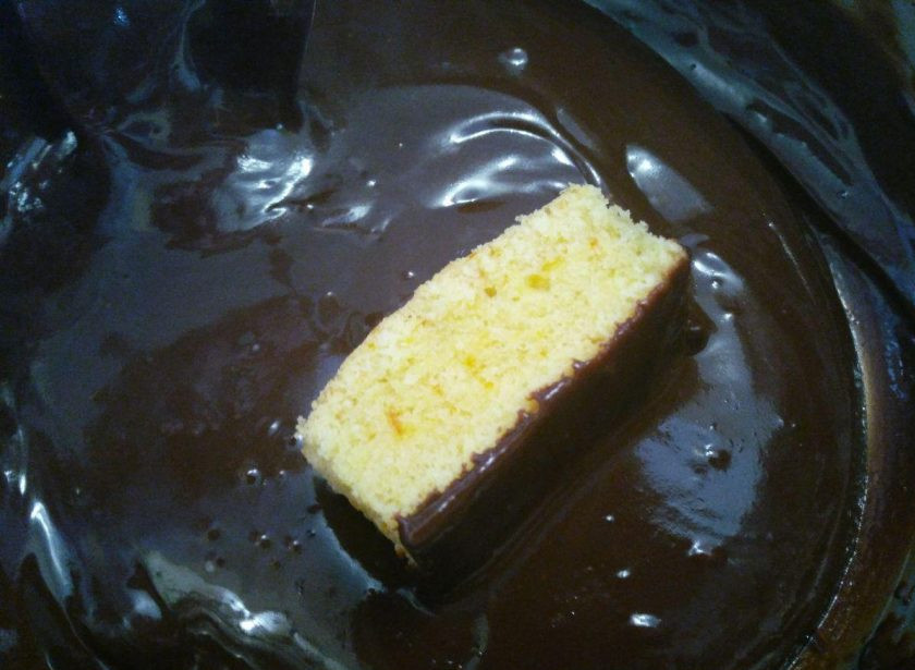 1. Этап. Пирожные Ламингтон, ароматизированные цедрой апельсина: Обмажьте шоколадной глазурью будущие пирожные со всех сторон.