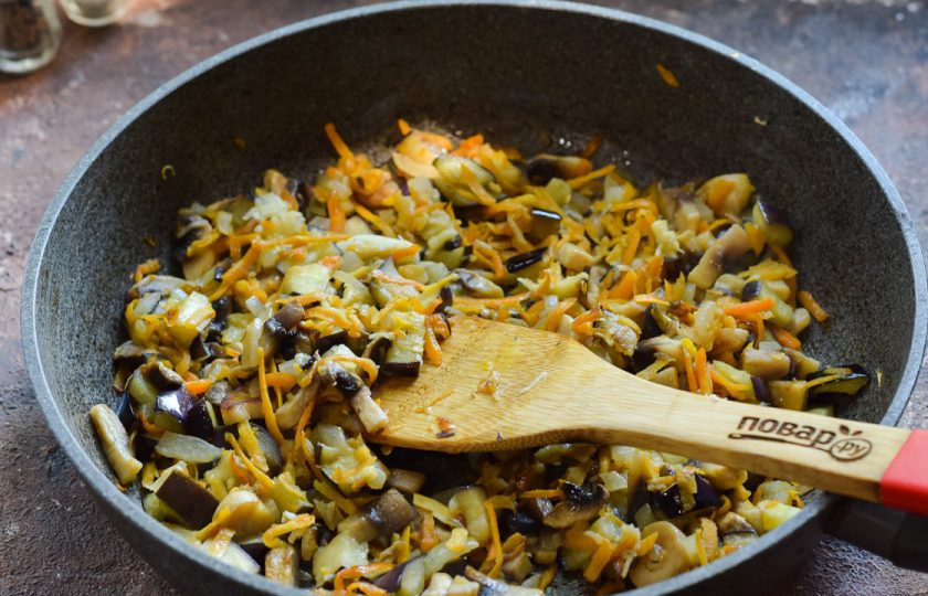1. Этап. Овощное рагу с рисом и баклажанами: В сковороде прогрейте масло и выложите овощи, чеснок. Жарьте 4-5 минут, помешивая.