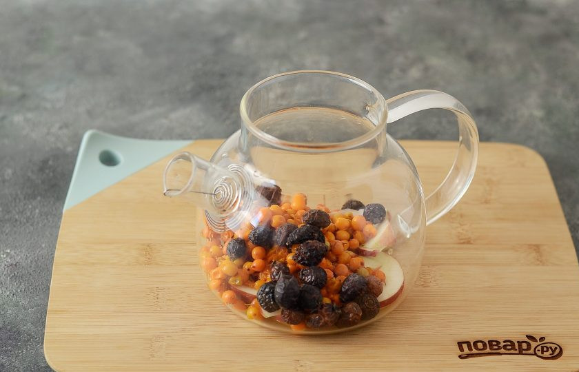 1. Этап. Чай с шиповником и облепихой: В заварочный чайник переложите всю облепиху, сахар, шиповник и яблоко.