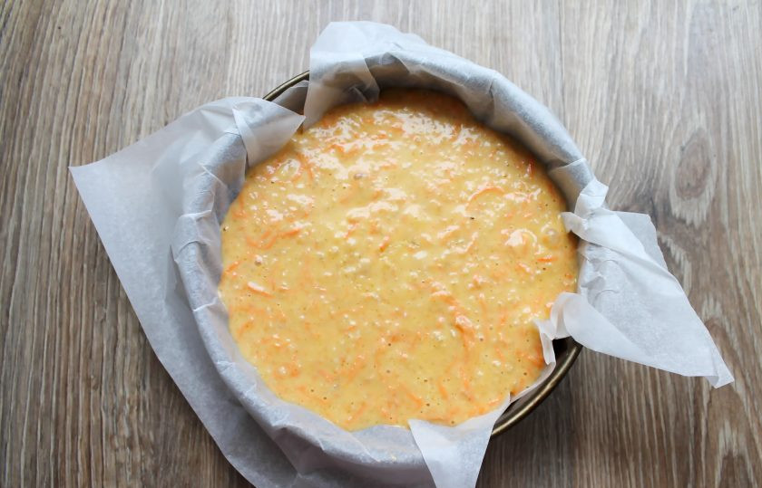 1. Этап. Овсяно-морковный пирог: Форму для запекания диаметром 22 сантиметра застелите бумагой для выпечки и переложите в нее тесто, разровняйте.