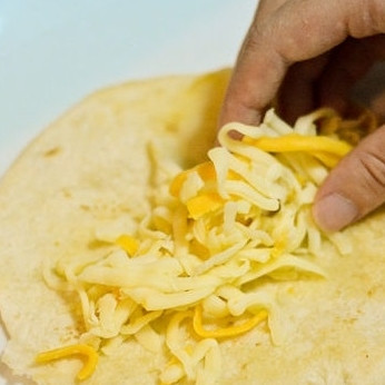 1. Этап. Энчиладас: 6. В обжаренную тортилью выложите тертый сыр.