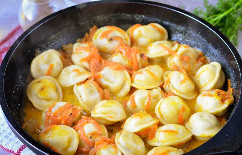 1. Этап. Пельмени тушеные с морковью и луком: Тушите пельмени под крышкой на медленном огне 15 минут, пока соус почти полностью не впитается в пельмени.