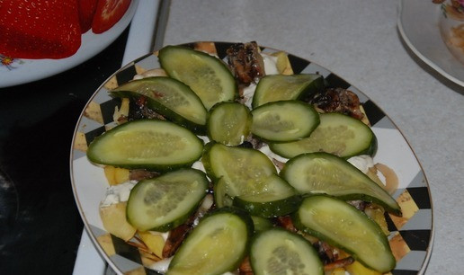 1. Этап. Теплый салат с мясными шариками: Выкладываем жареные грибы и нарезанные слайсы огурца.