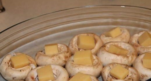 1. Этап. Шампиньоны, запеченные с сыром: Подготовленные шляпки шампиньонов положить в форму для запекания. Форму смазывать не нужно.