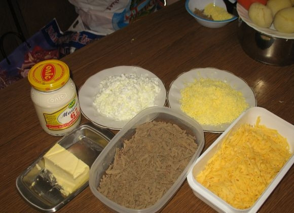 1. Этап. Новогодний печеночный торт: Отварите говяжью печень. Сварите яйца вкрутую. Говяжью печень, твёрдый сыр и варёные яйца натрите на крупной тёрке. Сложите в разную посуду.