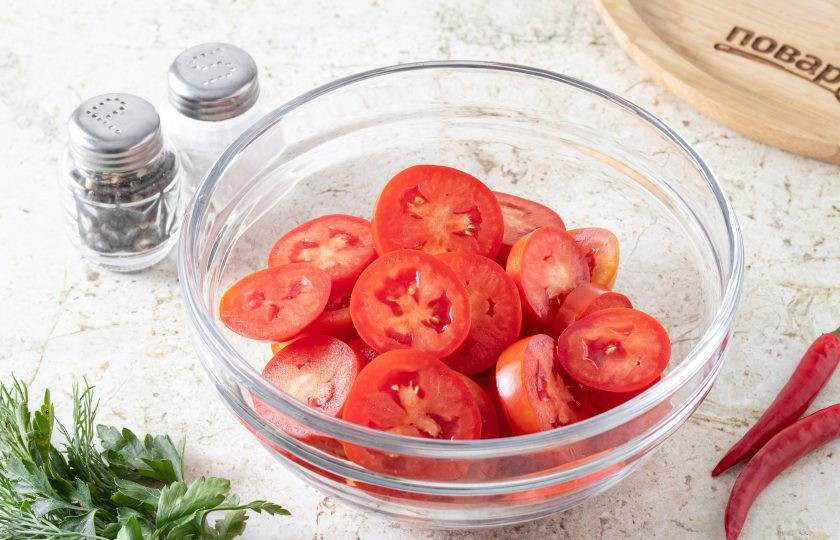 1. Этап. Острый салат из помидоров: Помидоры порежьте кружочками толщиной примерно 1 см. Переложите в глубокую миску.