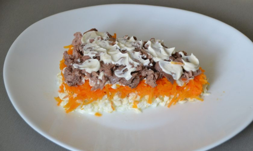 1. Этап. Салат Сырный ломтик на год Крысы: Выложите печень трески следующим слоем салата, сверху нанесите майонез.