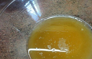 1. Этап. Карамельный медовик постный: Смешайте половину стакана растительного масла, 3 ст. л. меда, ванильный сахар и лимонный сок. Влейте теплую карамельную воду. Включите духовку для разогрева до 180°C.