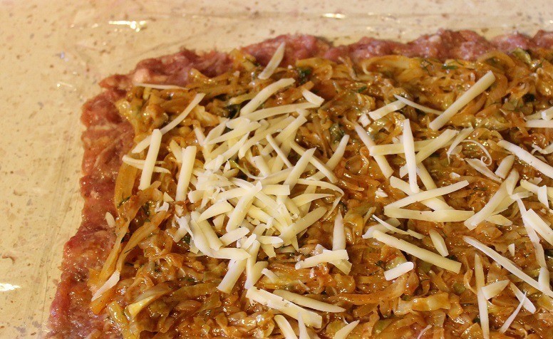 1. Stage. Meatloaf roll with cabbage: On top lay the stuffing from the cabbage and sprinkle with cheese grated on a coarse grater.