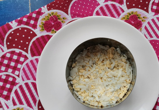 1. Этап. Слоёный рыбный салат Лето: *Я готовила салат в двух формочках по 10см в диаметре. Яйца отварить, остудить, очистить и натереть на крупной тёрке. Этот слой можно немного посолить.