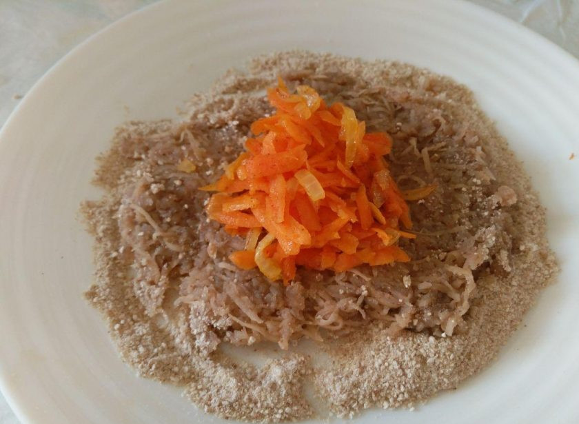 1. Этап. Гречневые зразы: Для формирования зраз на плоскую поверхность насыпьте немного панировочной смеси, распределите на ней порцию гречневого фарша в виде лепёшечки и выложите в центр порцию начинки.