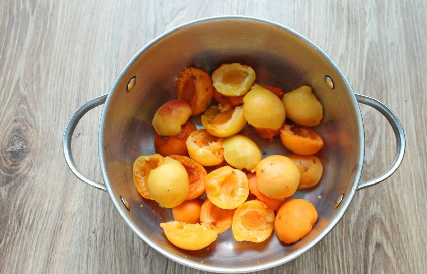 1. Этап. Варенье из абрикосов и киви: Абрикосы вымойте, обсушите и разделите на половинки, удалив косточки. Выложите половинки в кастрюлю или таз.