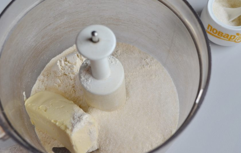 1. Этап. Ванильный сметанник: 2. В чашу кухонного комбайна положите холодное масло, сахар, муку и разрыхлитель. Включите машинку на пару минут, должны образоваться масляно-мучные крошки.