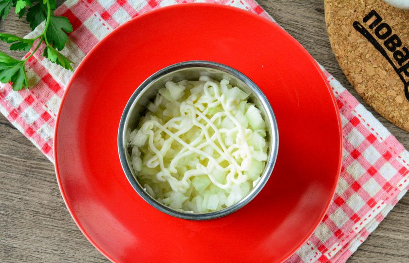 1. Этап. Салат Нежный вкус: Почистите репчатый лук, нарежьте его мелкими кубиками и выложите в салат вторым слоем. Лук слегка полейте майонезной сеточкой.