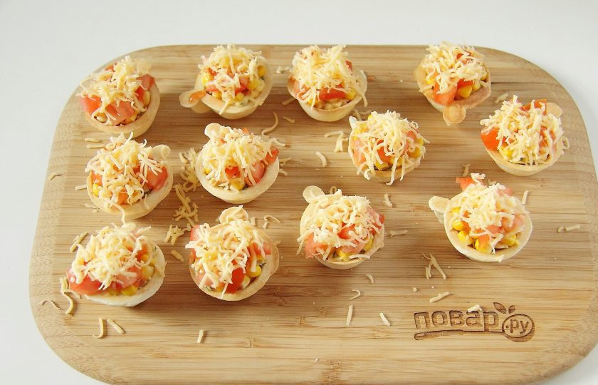 1. Этап. Запеченные тарталетки с курицей: Сверху посыпьте тарталетки оставшимся сыром.